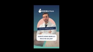 DERMA-Point poster with a doctor in a white coat against a blue gradient, posing with text 'Queste sono semplici macchie solari?'.